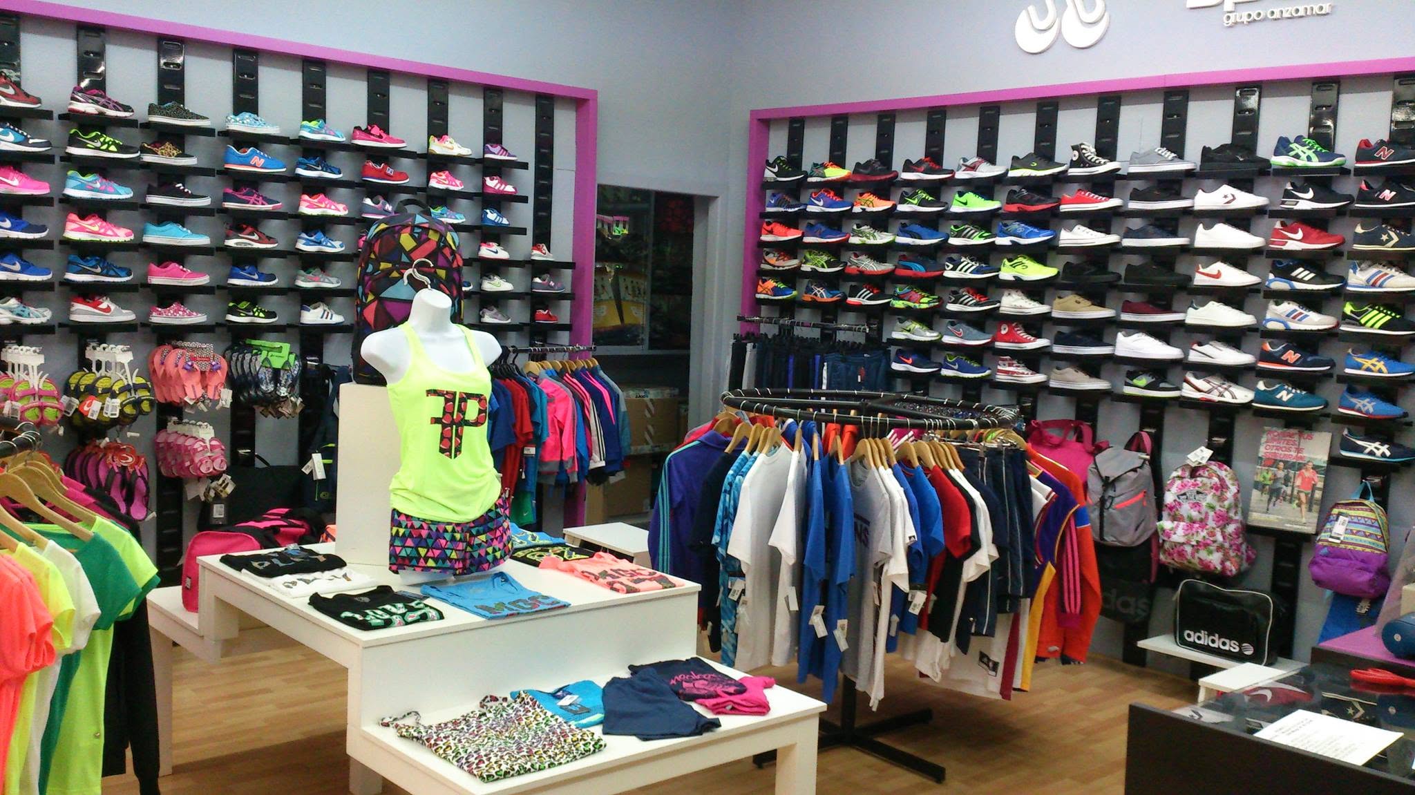 Interior de una tienda Point Sport de Grupo Anzamar, con paredes de zapatillas y textil deportivo